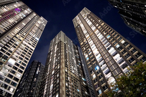 Low angle view of modern skyscrapers at night, towering above