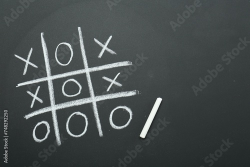 Tic tac toe game drawn on chalkboard, top view