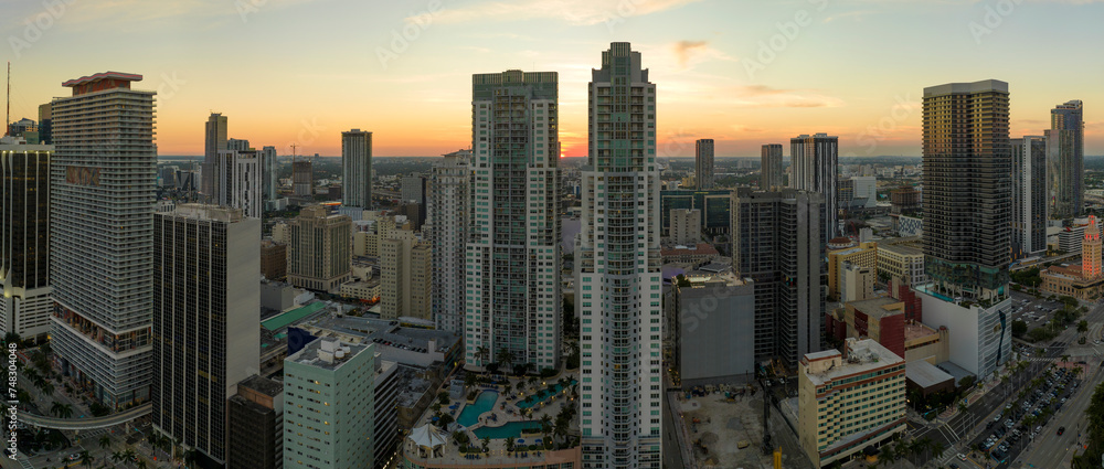 Fototapeta premium View from above of concrete and glass skyscraper buildings in downtown district of Miami Brickell in Florida, USA at sunset. American megapolis with business financial district at nightfall