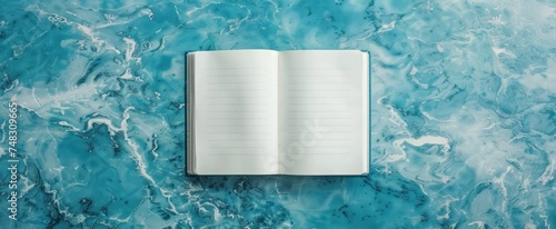 an empty notebook on a blue surface and a laptop on it