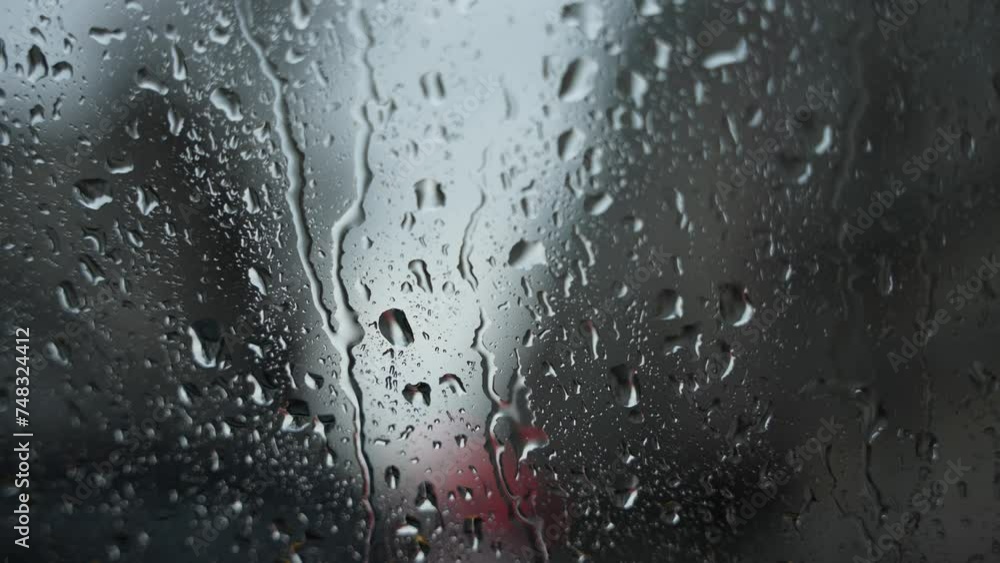 Raindrops on Window with Blurred Cityscape. Close-up of raindrops on glass with blurred urban background. Raindrops on Window with Blurred Cityscape. Close-up of raindrops on glass with blurred urban background.