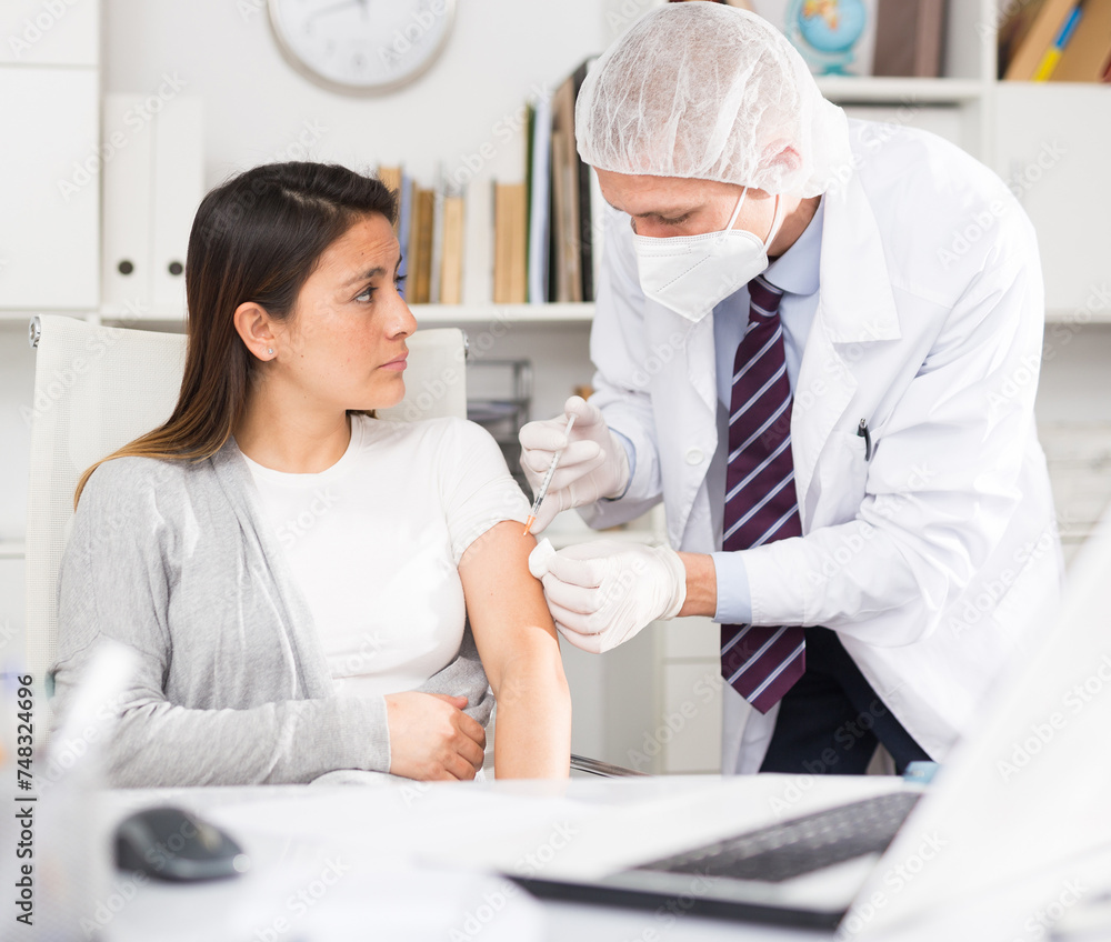 Obraz premium Doctor giving Covid-19 or flu antivirus vaccine shot to patient wear face mask protection at medical office