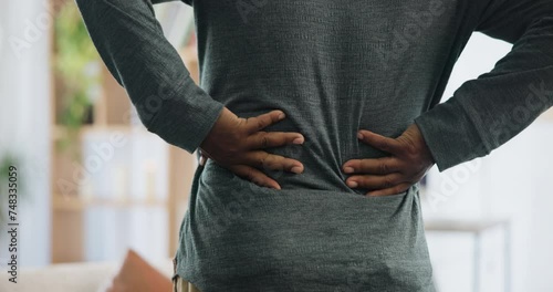 Back pain, hands and man in house with joint inflammation, crisis or anatomy risk closeup. Backache, problem or male person at home with kidney stones, discomfort or muscle, ache or posture disaster photo