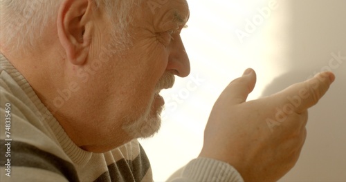 Face close-up. An elderly man engages in effective communication through nonviolent communication, combining verbal and nonverbal cues. He converses articulately, using gestures to enhance expression. photo