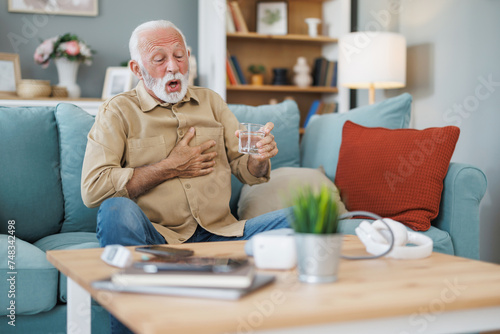 Man coping with high blood pressure at home photo