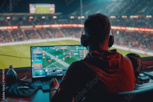 sports analyst at the monitor and football match on the background