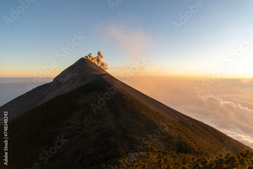 Der aktive Vulkan Fuego in Guatemala spuckt Lava und eine Rauchwolke aus photo