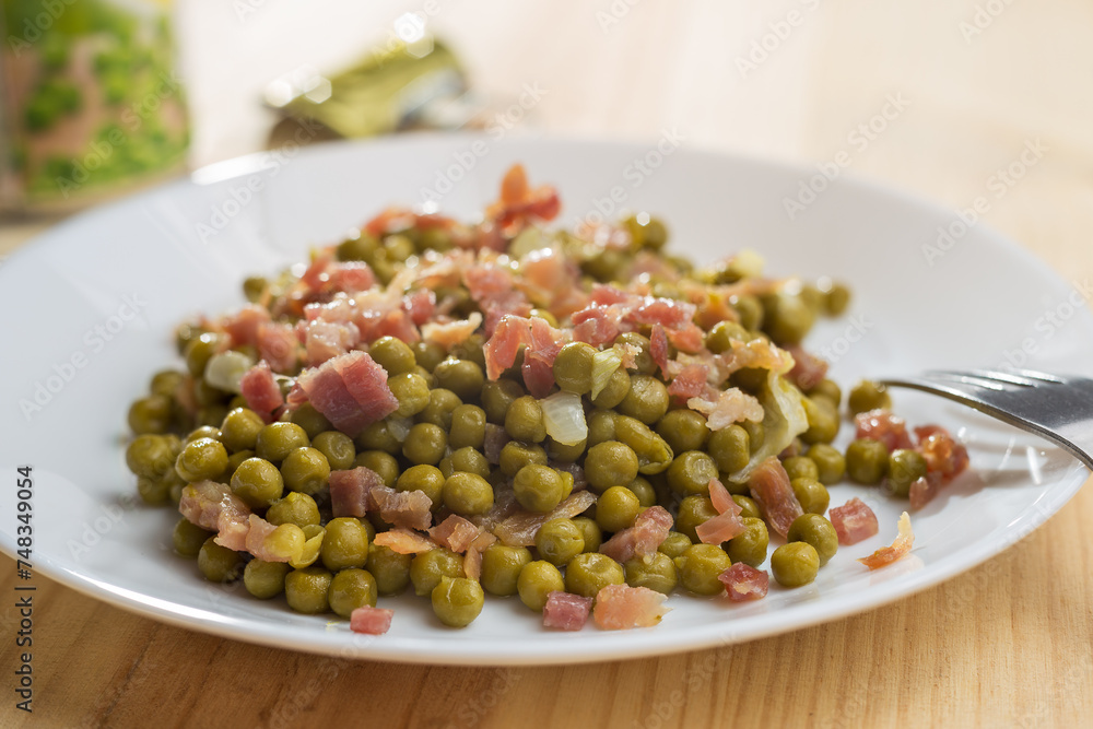 Dish of peas with ham and chives served on a white plate. Dish of peas with ham and chives served on a white plate.