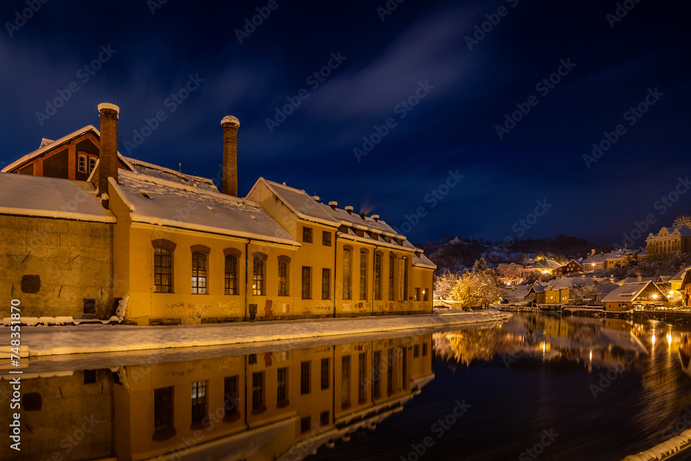 Fototapeta premium View of Czech Krumlov in winter, Czech Republic. Picturesque houses under the castle with snow-covered roofs. Narrow streets and the Vltava river. Travel and Holiday in Europe. UNESCO World Heritage.