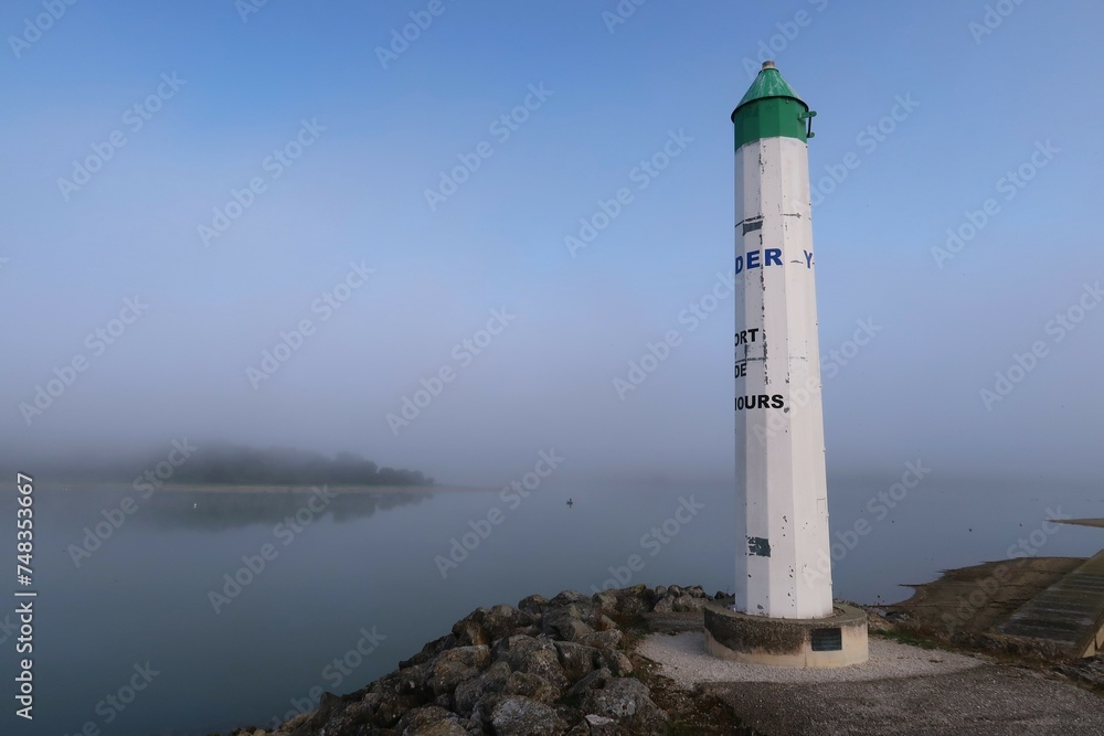 Lac du Der Chantecoq, en Champagne Ardenne, dans la région Grand Est, paysage avec le phare du port de Nemours dans la brume à l’aube (France)