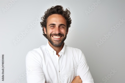 Portrait of a smiling man in a white shirt on a gray background