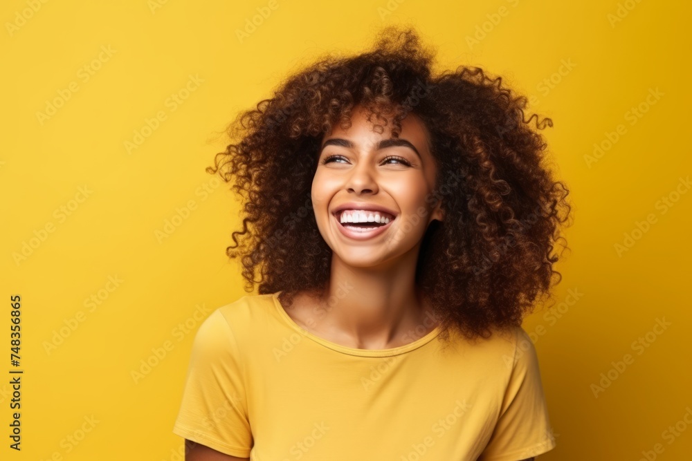 Portrait of a beautiful young african american woman laughing over yellow background Portrait of a beautiful young african american woman laughing over yellow background