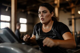 A focused woman runs on a treadmill in a gym, her face showing determination and sweat glistening on her skin.