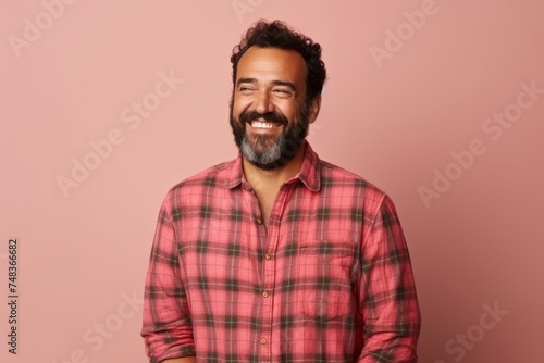 Portrait of a smiling man in a plaid shirt over pink background