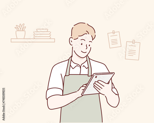 man in the kitchen reading on tablet. Hand drawn style vector design illustrations.