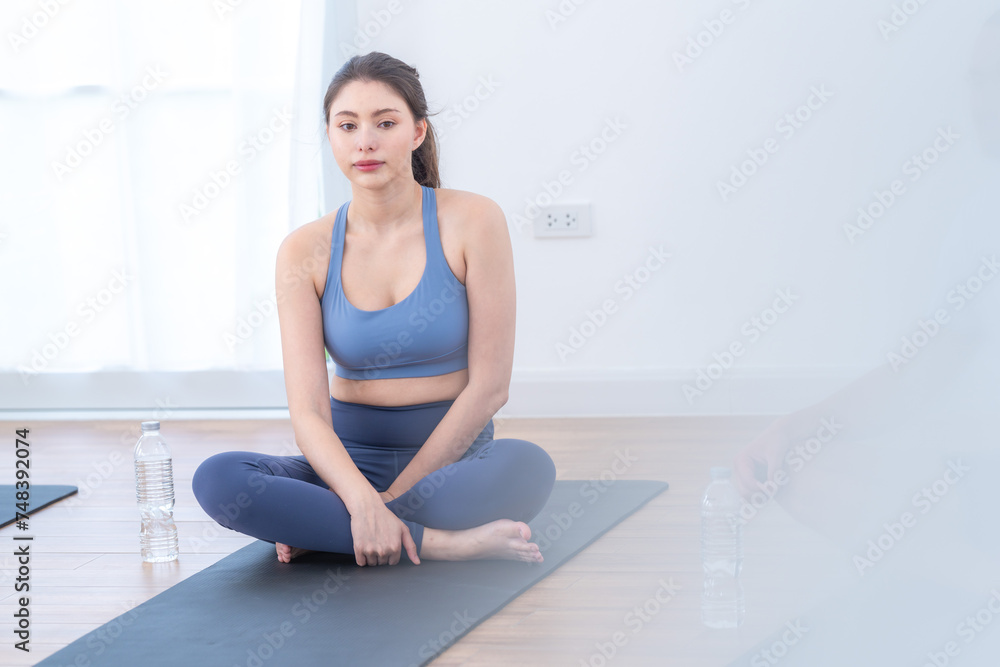 Two women confident training yoga. Athletic women in sportswear doing fitness stretching exercises at home in the living room. Sport and recreation concept. Yoga teacher is helping young woman. Two women confident training yoga. Athletic women in sportswear doing fitness stretching exercises at home in the living room. Sport and recreation concept. Yoga teacher is helping young woman.