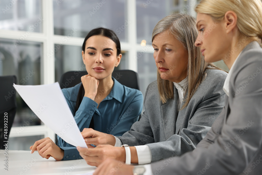 Lawyers working together with documents at table in office