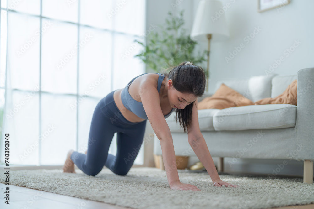 Two women confident training yoga. Athletic women in sportswear doing fitness stretching exercises at home in the living room. Sport and recreation concept. Yoga teacher is helping young woman.