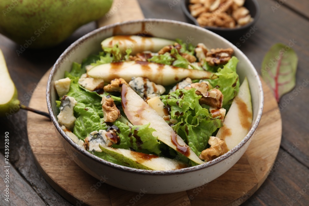 Delicious pear salad with sauce in bowl on wooden table, closeup Delicious pear salad with sauce in bowl on wooden table, closeup