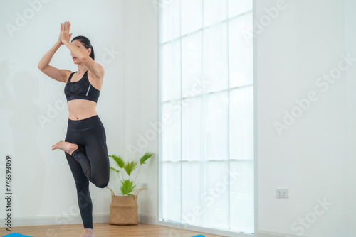 Fototapeta Naklejka Na Ścianę i Meble -  Two women confident training yoga. Athletic women in sportswear doing fitness stretching exercises at home in the living room. Sport and recreation concept. Yoga teacher is helping young woman.