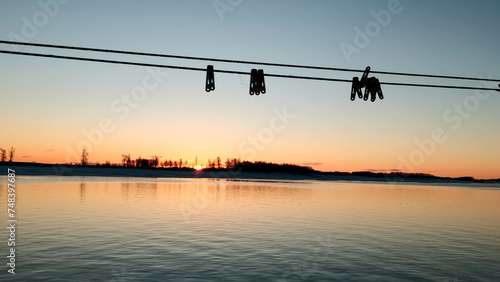 Beautiful sunset and blue sky over a forest lake at evening. Clip. Gentle lake ripples and ropes with clothespins. © Media Whale Stock