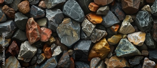 This image features a collection of brown and black rocks, showcasing various shapes and textures. The rocks appear to be of different sizes, with some displaying smooth surfaces while others have photo
