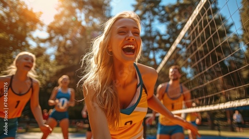 Fototapeta Naklejka Na Ścianę i Meble -  A group of friends laughing and playing volleyball in a sun-drenched park