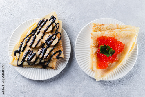 Pancakes stuffed with red caviar and bananas with chocolate