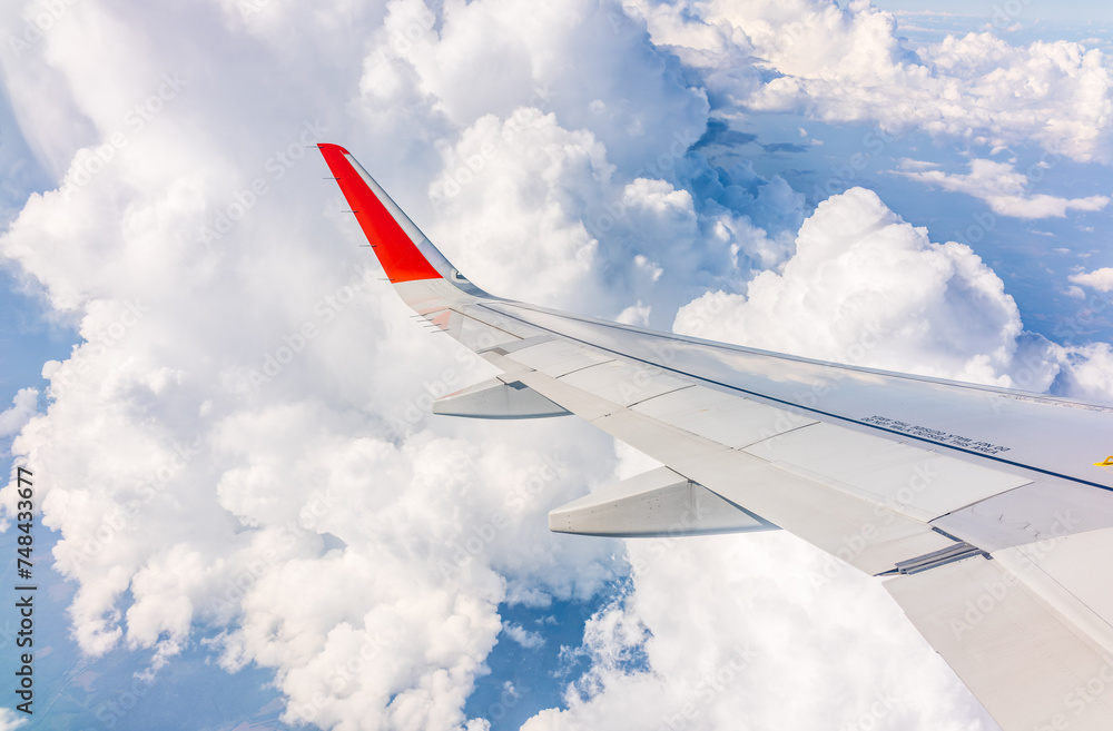 View from the airplane window at a beautiful cloudy sky and the airplane wing View from the airplane window at a beautiful cloudy sky and the airplane wing