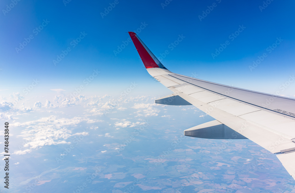 View from the airplane window at a beautiful cloudy sky and the airplane wing View from the airplane window at a beautiful cloudy sky and the airplane wing