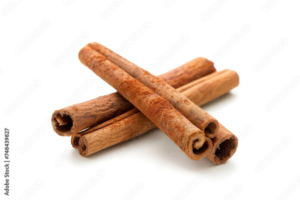 Cinnamon sticks crossed over each other on a white backdrop