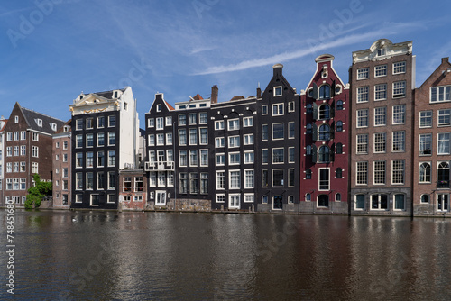 Typical Dutch canal houses along the Damrak in Amsterdam, The Netherlands.
