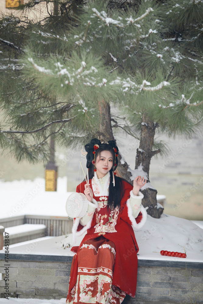 Naklejka premium An Asian girl outdoors wearing ancient clothing during the Chinese Spring Festival