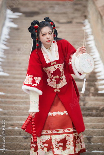 An Asian girl outdoors wearing ancient clothing during the Chinese Spring Festival