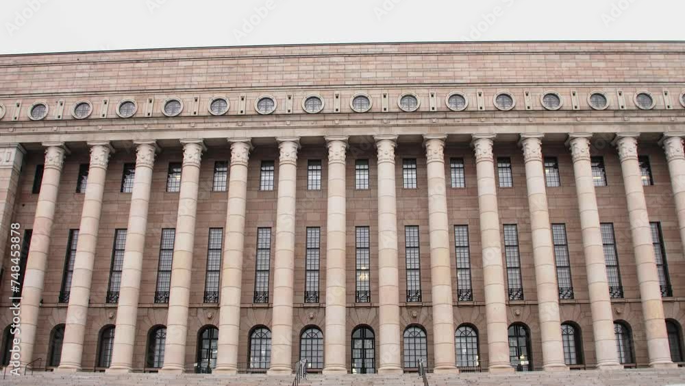 Wide shot of the Helsinki Parliament House façade on a cloudy day, no people in view, imposing architecture, camera tilt up Wide shot of the Helsinki Parliament House façade on a cloudy day, no people in view, imposing architecture, camera tilt up