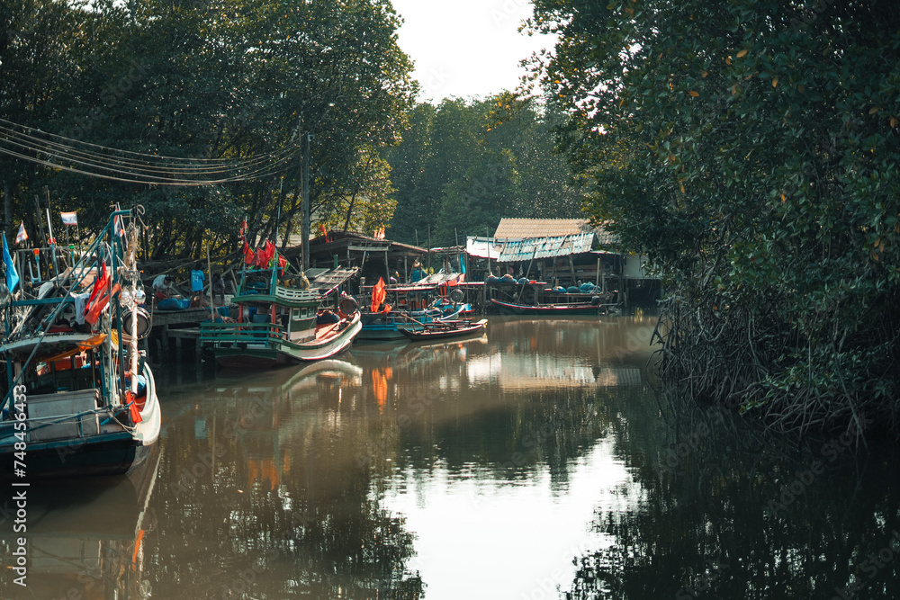 Obraz premium Fisherman's village and fishing boats at the canal by the sea.​Fisherman's village and fishing boats at the canal by the sea.​Fisherman's village and fishing boats at the canal by the sea.​
