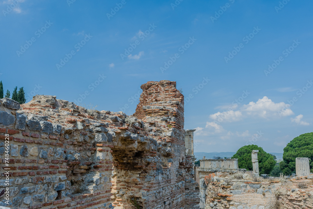 The ruins of an ancient wall with a clear blue sky in the background, in Ephesus, Turkiye