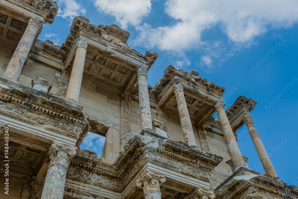Detailed view of the upper part of the Celsus Library facade with Corinthian columns against a blue sky, in Ephesus, Turkiye
