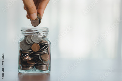 Glass jar with coins, a han...