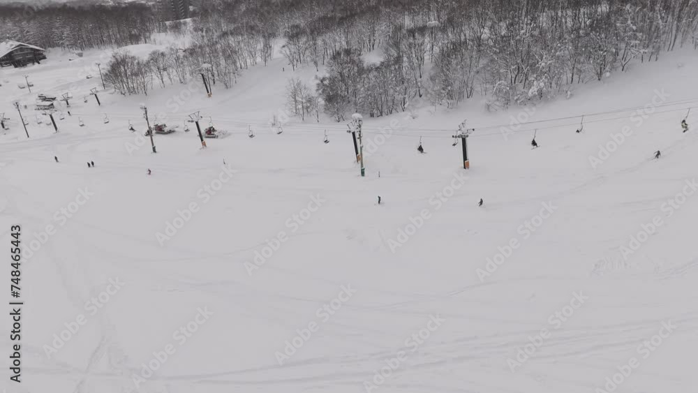Tracking Shot of a skier traversing the mountains in Hokkaido, Japan near a ski lift. Tracking Shot of a skier traversing the mountains in Hokkaido, Japan near a ski lift.