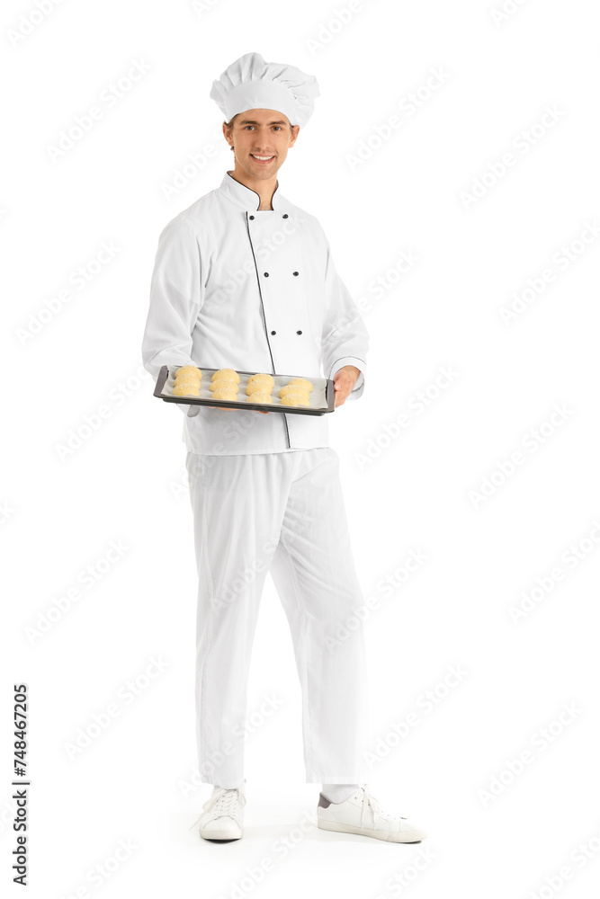Handsome young chef holding tray with fresh raw buns on white background Handsome young chef holding tray with fresh raw buns on white background