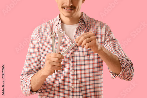 Young man with wrenches on ...