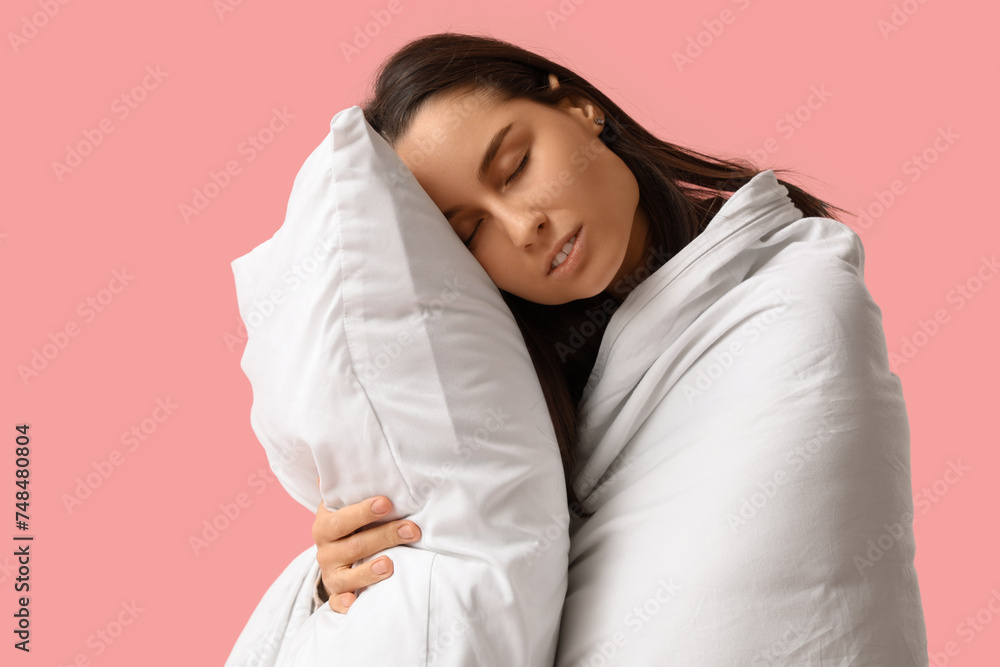 Sleepy young woman with blanket and pillow on pink background Sleepy young woman with blanket and pillow on pink background