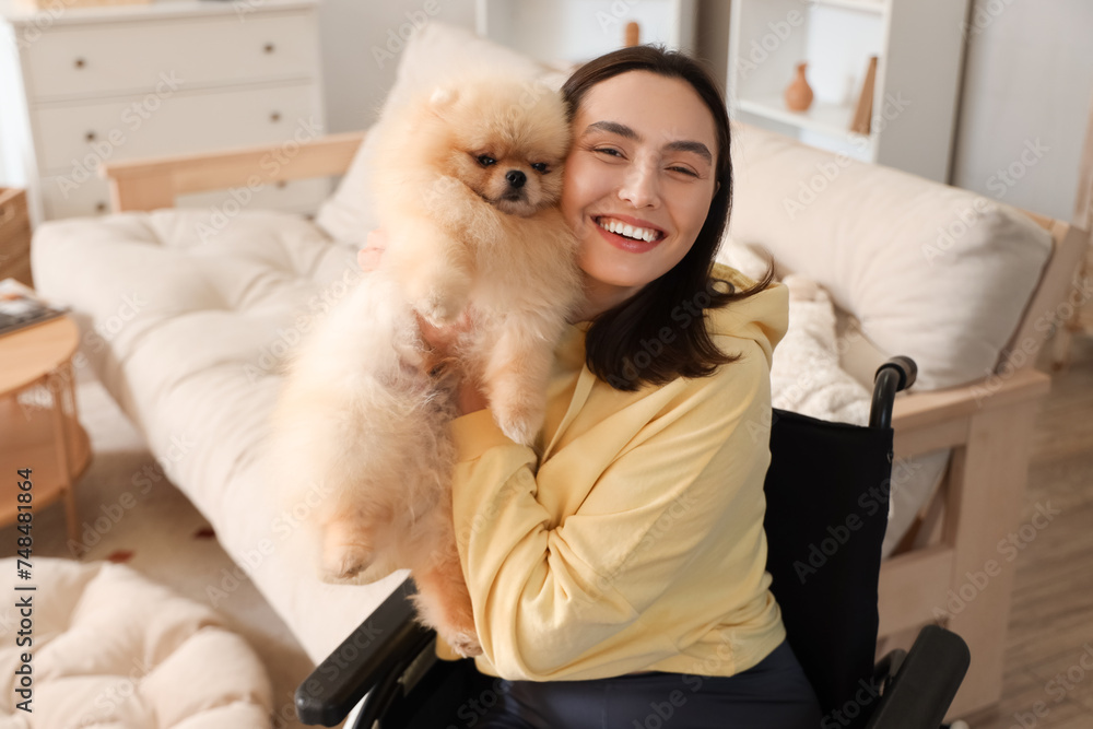 Sporty young woman in wheelchair with Pomeranian dog at home Sporty young woman in wheelchair with Pomeranian dog at home
