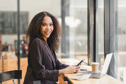 Confident African American businesswoman with Laptop at Cafe.