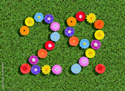 number written with colorful flowers on green clover background photo