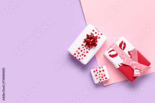 Gift boxes with hearts and lipstick prints on lilac background. Valentine's Day celebration