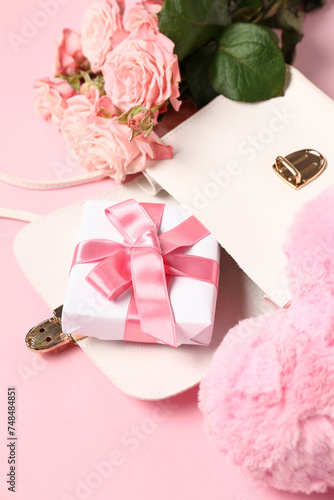 Purse with fit box, heart and bouquet of roses on pink background. Valentine's Day celebration