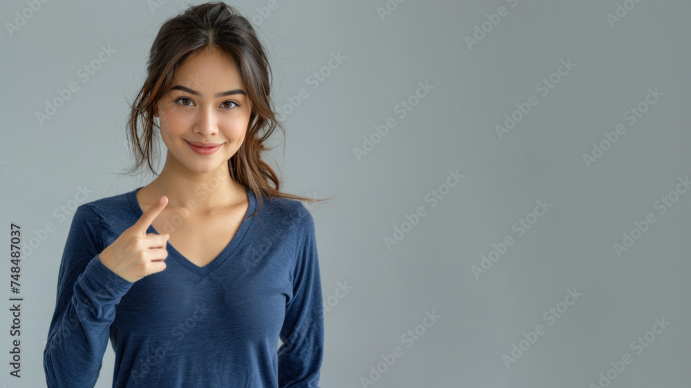 Malay woman in blue ribbed V-Neck Body, hands in point away pose Malay woman in blue ribbed V-Neck Body, hands in point away pose