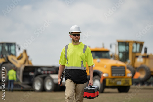 The inspector. Builder inspector with hardhat helmet on construction site. Inspector Man in hardhat. Construction worker outdoor. Construction worker engineer at worksite. Building inspection.